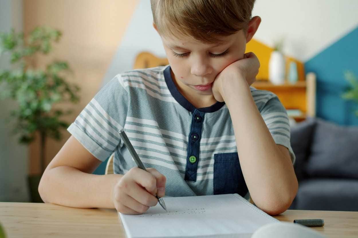 boy writing with pencil